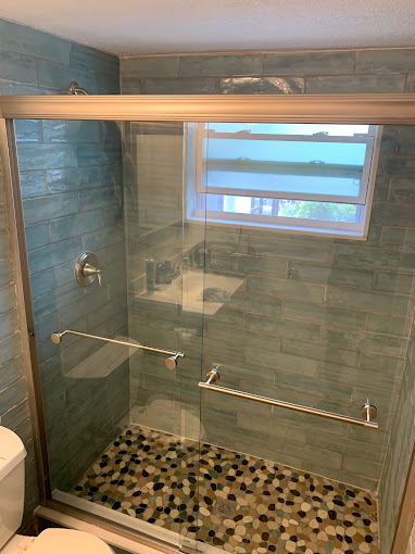 Frameless glass shower door installation with modern hardware